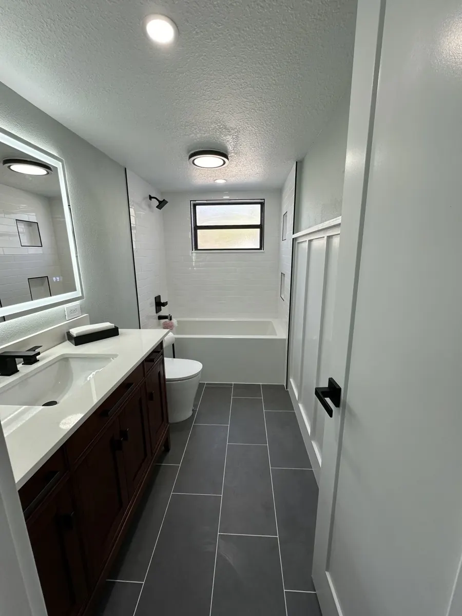 White tile bath & charcoal flooring